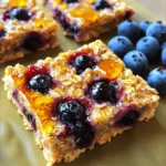 - 2 cups rolled oats - 1 cup fresh or frozen blueberries - 1/2 cup almond butter (or any nut butter) - 1/4 cup honey or maple syrup - 1/2 teaspoon cinnamon - 1/4 teaspoon salt - 1/2 cup almond flour (or whole wheat flour) - 1/4 cup chopped nuts (walnuts or pecans) - 1/4 cup chia seeds (optional, for added nutrition) Each bar contains about: - Calories: 150 - Protein: 4g - Carbohydrates: 20g - Fat: 7g - Fiber: 3g - Sugar: 5g Rolled oats are great for your heart. They help lower cholesterol. Blueberries are packed with antioxidants. They support brain health and boost your mood. Almond butter adds protein and healthy fats. It keeps you full longer. Honey or maple syrup gives natural sweetness. They provide quick energy without a sugar crash. Cinnamon adds flavor and may lower blood sugar. Salt enhances taste and balances flavors. Almond flour is gluten-free and rich in vitamin E. Chopped nuts add crunch and healthy omega-3s. Chia seeds are full of fiber and protein. They help digestion and improve heart health. First, gather all your ingredients. You will need: - 2 cups rolled oats - 1 cup fresh or frozen blueberries - 1/2 cup almond butter - 1/4 cup honey or maple syrup - 1/2 teaspoon cinnamon - 1/4 teaspoon salt - 1/2 cup almond flour - 1/4 cup chopped nuts - 1/4 cup chia seeds (optional) Next, preheat your oven to 350°F (175°C). Line an 8x8 inch baking dish with parchment paper. Leave some overhang. This helps with easy removal later. In a large bowl, mix the rolled oats, almond flour, cinnamon, and salt. Make sure they blend well. Meanwhile, warm the almond butter and honey in a microwave-safe bowl. Heat it for 20-30 seconds. Stir until smooth and well combined. Now, pour this warm mixture into the dry ingredients. Mix until everything is combined. Gently fold in the blueberries, chopped nuts, and chia seeds. Be careful not to break the blueberries. Transfer the mixture into your lined baking dish. Press it down firmly. This makes an even layer. Use a spatula or your hands to flatten the top. Bake in your preheated oven for 25-30 minutes. Look for golden brown edges. This shows they are done. Once baked, let the bars cool in the pan for at least 15 minutes. Use the parchment overhang to lift them out. Place them on a wire rack to cool completely. After they cool, cut the bars into squares or rectangles. Store them in an airtight container. They last up to a week or you can freeze them for longer storage. To get the best texture in your blueberry oat breakfast bars, use rolled oats. They give a chewy feel that blends well with the soft blueberries. Mix the dry ingredients well before adding the wet ones. This step helps everything combine evenly. When you press the mixture into the baking dish, pack it tightly. A firm pack keeps the bars from crumbling. Keep an eye on the oven. Baking until golden brown on the edges adds a nice crunch. One common mistake is overmixing the blueberry mixture. Be gentle when folding in the blueberries. If you break them, the bars will turn purple and mushy. Another mistake is not lining the baking dish with parchment paper. This can make it hard to remove the bars later. Also, don’t skip cooling the bars in the pan. If you cut them too soon, they may fall apart. For a fun twist, try adding seasonal fruits. In summer, mix in diced peaches or strawberries. In fall, sliced apples or pumpkin can add a lovely taste. You can also switch the nuts based on the season. Use pecans in the fall or walnuts in spring. Chia seeds are a great option for added nutrients, but you can skip them if you prefer. Always use fresh ingredients when possible to enhance the flavor of your bars. {{image_2}} If you have nut allergies, you can easily make swaps. Use sunflower seed butter instead of almond butter. This option keeps the bars creamy and tasty. You can also skip the chopped nuts entirely. The bars will still be delicious and safe. You can make these bars your own by adding flavors. Try mixing in vanilla extract for a warm, sweet taste. Adding spices like nutmeg or ginger can give a nice kick. You can also throw in different fruits. Dried cranberries, apples, or peaches work well with blueberries. To make these bars vegan, replace honey with maple syrup. This swap keeps the sweetness without using animal products. For a gluten-free option, make sure to use certified gluten-free oats and almond flour. These changes let everyone enjoy these tasty bars! To keep your blueberry oat breakfast bars fresh, store them in an airtight container. This helps maintain their moisture and flavor. Keep the container at room temperature if you plan to eat them within a week. For longer storage, refrigeration is a good option. Just make sure the bars are completely cool before sealing them up. You can freeze these bars for later enjoyment. Cut the bars into pieces before freezing. Wrap each piece tightly in plastic wrap, then place them in a freezer-safe bag. This way, you can grab a bar anytime. To thaw, simply take a bar out and let it sit at room temperature for about 30 minutes. You can also warm it in the microwave for a few seconds. These bars last up to a week when stored properly at room temperature. If refrigerated, they can last up to two weeks. For frozen bars, they stay good for about three months. Always check for any signs of spoilage before eating. To enjoy them at their best, consume within these time frames. Yes, you can use frozen blueberries. They work great in these bars. Just add them straight from the freezer. This keeps them from breaking apart too much. Frozen berries can add a nice burst of juice. To make these bars vegan, use maple syrup instead of honey. You can also swap almond butter for any nut or seed butter. This way, you keep the same great taste while making it plant-based. Absolutely! You can add protein powder to boost nutrition. Just replace a bit of the almond flour. This helps keep the texture right while adding extra protein. Start with 1/4 cup and see how it mixes in. To reheat the bars, place them in the microwave for about 15-20 seconds. This warms them up without making them too soft. If you prefer, you can use an oven at 350°F for about 5 minutes. Enjoy them warm with a drizzle of honey! In this post, we covered key ingredients and their health benefits. We shared simple steps for preparation, baking, cooling, and cutting. I included useful tips to avoid mistakes and achieve the best texture. You can try variations for allergies or dietary needs. Lastly, I provided storage tips to keep your breakfast bars fresh. I hope this guide helps you create tasty and healthy blueberry oat bars with ease. Enjoy your baking!