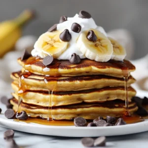- 1 cup all-purpose flour - 2 tablespoons sugar - 1 tablespoon baking powder - 1/2 teaspoon salt - 1 cup milk - 1 large ripe banana, mashed - 1 large egg - 2 tablespoons melted butter (plus extra for cooking) - 1/2 cup chocolate chips - 1/2 teaspoon vanilla extract - Optional toppings: sliced bananas, whipped cream, maple syrup Gathering the right ingredients is key to making delicious chocolate chip banana pancakes. Each item plays a big role in creating that perfect fluffy texture. Start with 1 cup of all-purpose flour. This is the base for your pancakes. Next, add 2 tablespoons of sugar. This gives a little sweetness without being overpowering. Then, include 1 tablespoon of baking powder. This helps the pancakes rise and stay light. Don’t forget 1/2 teaspoon of salt. Salt balances the sweetness and enhances the flavors. You will need 1 cup of milk for moisture. It makes the batter smooth and creamy. Grab 1 large ripe banana and mash it well. This adds natural sweetness and flavor. You also need 1 large egg. The egg binds everything together and adds richness. Melt 2 tablespoons of butter. This adds flavor and keeps the pancakes from sticking. Add in 1/2 cup of chocolate chips. This is where the magic happens; they melt perfectly in the warm pancakes. Finally, don’t skip 1/2 teaspoon of vanilla extract for that lovely aroma and taste. For toppings, you can use sliced bananas, whipped cream, or maple syrup. These add fun flavors and make your pancakes extra special. With all these ingredients, you’re ready to make a breakfast treat that everyone will love! {{ingredient_image_1}} First, grab a large mixing bowl. Add 1 cup of all-purpose flour, 2 tablespoons of sugar, 1 tablespoon of baking powder, and 1/2 teaspoon of salt. Use a whisk to mix these ingredients well. Whisking helps to blend the flour and baking powder evenly. This step is key. It ensures that the pancakes rise well, giving you that light and fluffy texture. In another bowl, combine 1 cup of milk, 1 large ripe banana (mashed), 1 large egg, 2 tablespoons of melted butter, and 1/2 teaspoon of vanilla extract. Mix these until you get a smooth mixture. This is where the banana adds flavor. It blends nicely with the milk and butter, making your pancakes moist and delicious. Now, pour the wet mixture into the bowl with the dry ingredients. Stir gently until just combined. The batter should still look slightly lumpy. Overmixing can lead to tough pancakes. So, take your time and fold the mixture carefully. When you see a few dry spots, you’re ready to add the chocolate chips. Preheat a non-stick skillet over medium heat. Add a small amount of butter to grease the surface. Pour about 1/4 cup of batter for each pancake. Cook until bubbles form on top, about 2-3 minutes. This shows they are ready to flip. Carefully turn them over and cook for another 1-2 minutes until golden brown. Keep an eye on the heat to avoid burning. Repeat this with the remaining batter and enjoy your pancakes warm! To make your pancakes fluffy, use room temperature ingredients. Cold milk and eggs can make the batter dense. Let them sit out for about 30 minutes. Resting the batter for 10 minutes also helps. It allows the flour to absorb the moisture fully. This step makes your pancakes rise better during cooking. Use a non-stick skillet for easy flipping. Preheat it over medium heat. Add a small amount of butter to the skillet before pouring in the batter. If the heat is too high, the pancakes can burn on the outside while staying raw inside. If they cook too fast, lower the heat slightly. Fold in the chocolate chips gently. This keeps the batter light and airy. Avoid stirring too much, as it can lead to dense pancakes. For even chocolate placement, sprinkle some chips on top of the batter once it is in the skillet. This way, you prevent heavy chocolate at the bottom. Pro Tips Perfectly Ripe Bananas: Use bananas that are very ripe, with lots of brown spots, as they provide the best flavor and natural sweetness for your pancakes. Don’t Overmix: When combining wet and dry ingredients, mix just until combined. A few lumps are okay; overmixing can lead to dense pancakes. Even Heat Distribution: Make sure your skillet or griddle is evenly heated to prevent pancakes from burning. Test with a drop of water; it should sizzle and evaporate quickly. Keep Them Warm: If making multiple pancakes, keep cooked ones warm in a low oven (200°F or 93°C) while you finish the batch. {{image_2}} You can make your pancakes healthier with a few swaps. Try using whole wheat flour instead of all-purpose flour. Whole wheat adds fiber and nutrients. Oat flour is another great choice. It gives a nutty flavor and works well. For sweetening, think about using honey or maple syrup. These natural options can replace sugar. They add a different taste and are often less processed. Want to mix it up? Try adding nuts to your batter. Chopped walnuts or pecans bring crunch and flavor. You could also sprinkle in some cinnamon or nutmeg. These spices add warmth and depth. Don’t forget about chocolate! You can use dark chocolate chips or even white chocolate. Each type offers a unique taste. You can even blend different chocolates for a fun twist. If you follow a dairy-free diet, use almond milk or soy milk instead of regular milk. For butter, try coconut oil or a dairy-free spread. These swaps keep the flavor without dairy. If you're vegan, you can skip the egg. Use a flaxseed or chia seed mix instead. Just mix one tablespoon of seeds with three tablespoons of water. Let it sit for five minutes to thicken. This mix binds the pancakes just like an egg would. To keep leftover pancakes fresh, place them in an airtight container. You can stack them with parchment paper between each pancake to avoid sticking. Properly stored, they last about 3 to 4 days in the fridge. When reheating, use a microwave or skillet. For the microwave, place a pancake on a plate and cover it with a damp paper towel. Heat for about 20-30 seconds until warm. If you prefer the skillet, heat it over low heat with a touch of butter. Cook each pancake for about 1-2 minutes on both sides. This method adds a nice crispness. Freezing pancakes is easy and a great way to save time. Start by letting the pancakes cool completely. Then, stack them with parchment paper in between each one to prevent sticking. Wrap the entire stack in plastic wrap or place them in a freezer bag. Squeeze out as much air as possible. They can stay fresh for up to 2 months in the freezer. To thaw frozen pancakes, take them out and leave them in the fridge overnight. If you're in a hurry, you can microwave them directly from the freezer. Heat for about 1 minute, flipping halfway through. For a crispy finish, use a skillet over low heat for a few minutes. Enjoy your pancakes just like fresh! Yes, you can make these pancakes gluten-free. Use gluten-free flour blends available at stores. Look for blends made from rice flour, almond flour, or coconut flour. These blends work well in pancakes. Just replace the all-purpose flour with your choice of flour blend. Adjust the liquid slightly if needed since gluten-free flours can absorb more moisture. If you need an egg substitute, there are many options. You can use 1/4 cup of unsweetened applesauce for each egg. Mashed banana works great too; use 1/4 cup for one egg. You can also use flaxseed meal. Mix 1 tablespoon of flaxseed with 3 tablespoons of water and let it sit for a few minutes. This mixture acts like an egg in pancakes. To boost nutrition, add fruits like blueberries or diced apples into the batter. You can also mix in oats or whole wheat flour for more fiber. Chia seeds or flax seeds add healthy fats and fiber too. These options enhance flavor and make the pancakes healthier without losing their tasty appeal. Pancakes stay fresh in the fridge for about 3 to 4 days. Store them in an airtight container to keep them moist. When you’re ready to eat, just reheat them in the microwave or on the skillet. For longer storage, consider freezing them. They can last up to 2 months in the freezer if wrapped well. In this post, we explored a simple, tasty pancake recipe using easy ingredients. We covered steps to mix and cook the batter for fluffy pancakes. You now know tips for variations and storage options. These pancakes can fit any diet and taste preference. Enjoy making them at home, and share the joy with family or friends. Simple tools and a bit of practice will lead you to perfect pancakes every time. Now, get cooking and treat yourself!